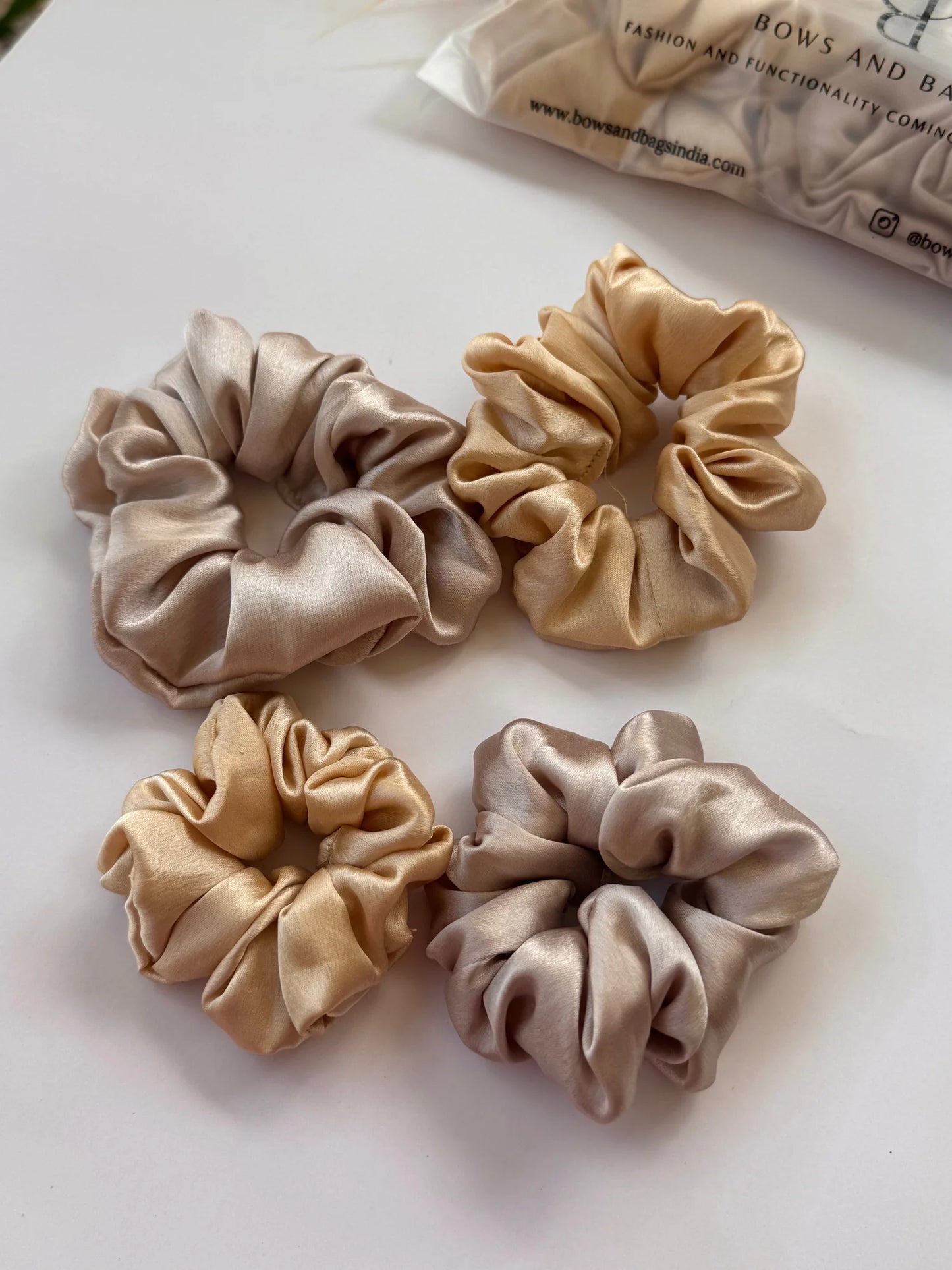 Four premium satin scrunchies in gold and champagne silver, mini and large sizes, by Bows and Bags India handmade hair