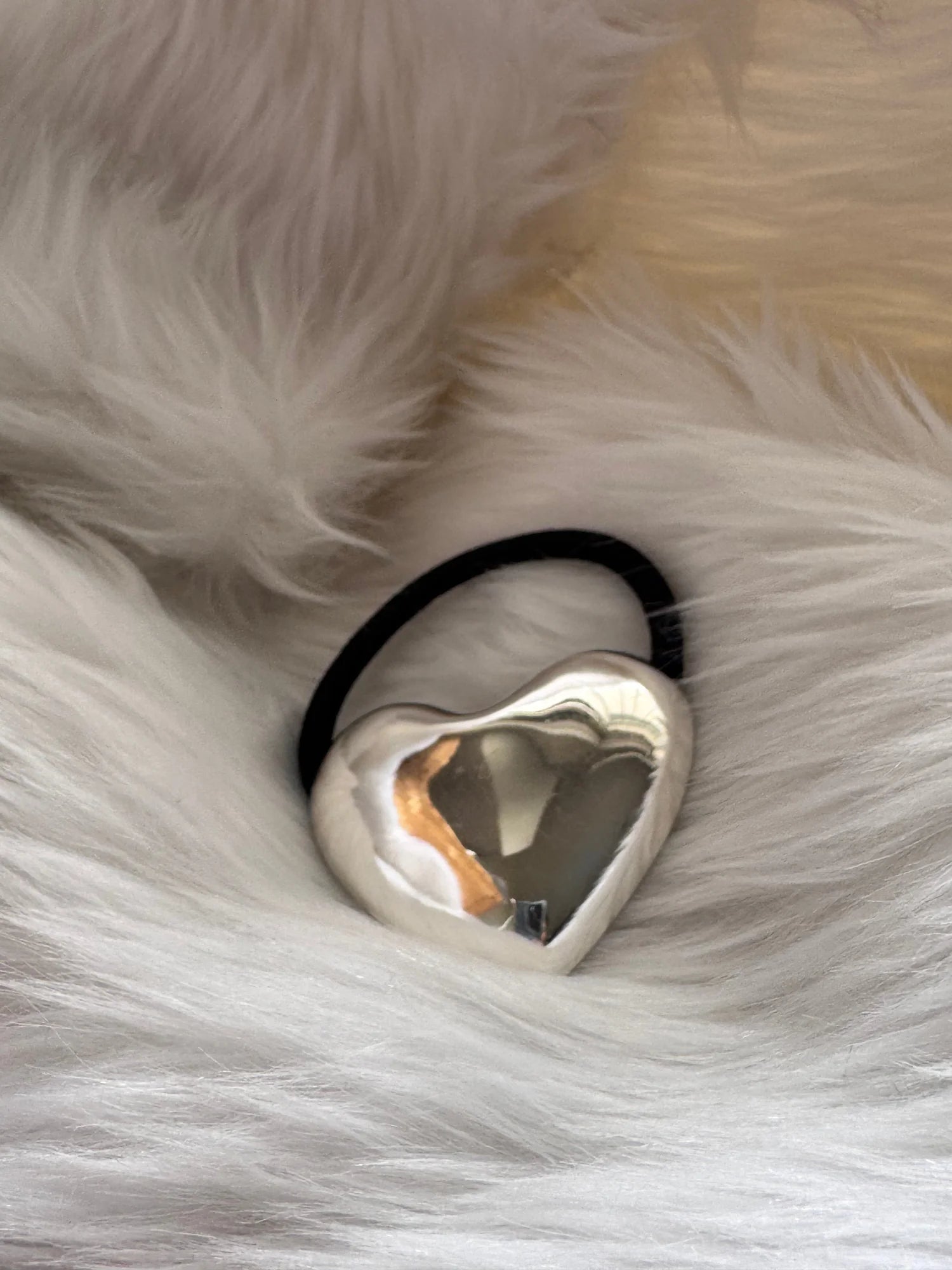 Silver heart metal rubber band with polished chrome finish on soft white fabric by Bows and Bags India