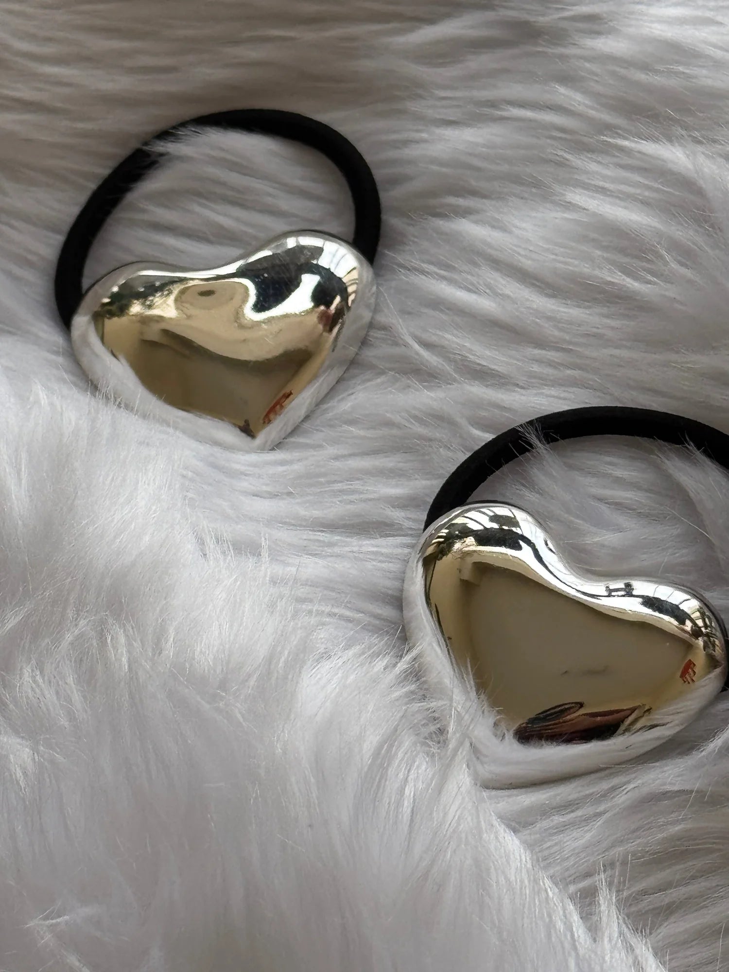 Silver heart metal rubber band hair tie with polished chrome finish by Bows and Bags India on white fur background