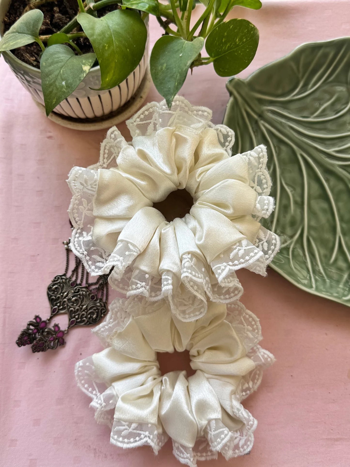 Cream satin scrunchies with delicate lace trim detail by Bows and Bags India, handmade hair accessories displayed on pink