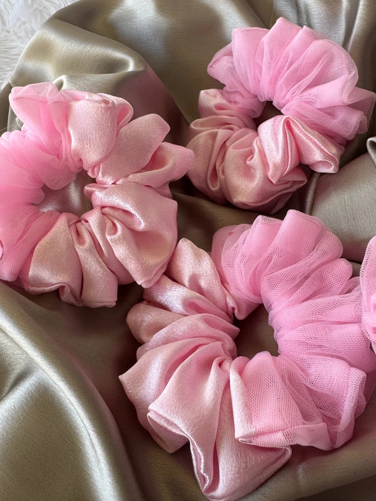 Baby pink satin and net scrunchies with delicate tulle borders, handmade hair accessories by Bows and Bags India, displayed