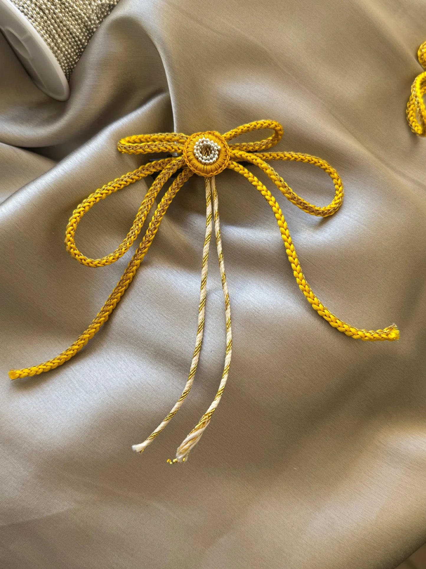 Sun Bow Hair Clip in gold with intricate detailing on cream silk fabric by Bows and Bags India