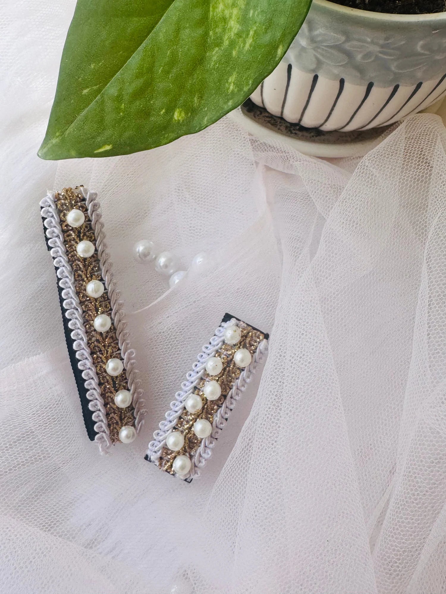 Swiss pearls handmade hair clip pair by Bows and Bags India featuring pearl and metallic embroidery on white textured fabric