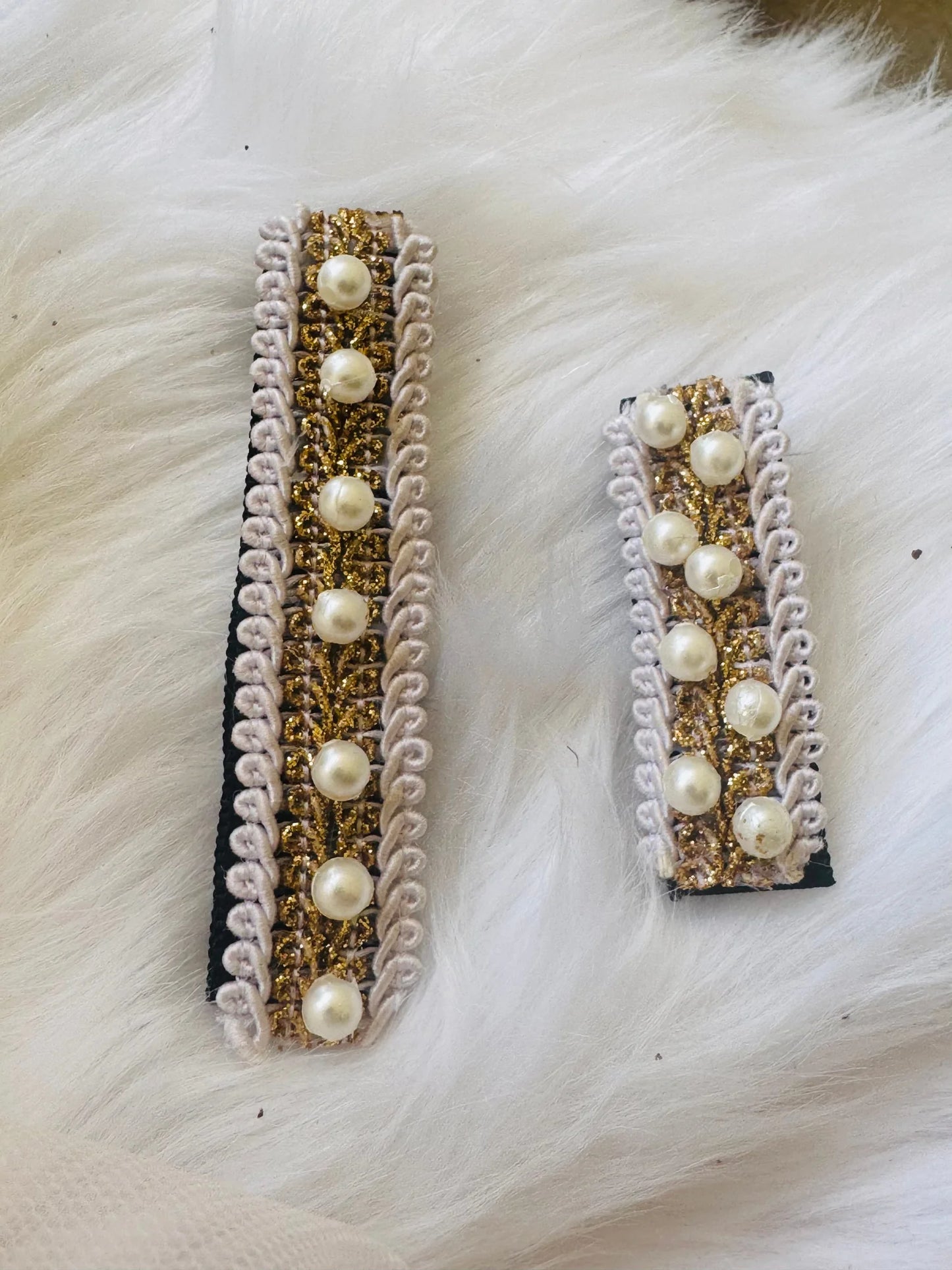 Pair of handmade pearl hair clips with gold glitter and lavender lace trim by Bows and Bags India, displayed flat lay on