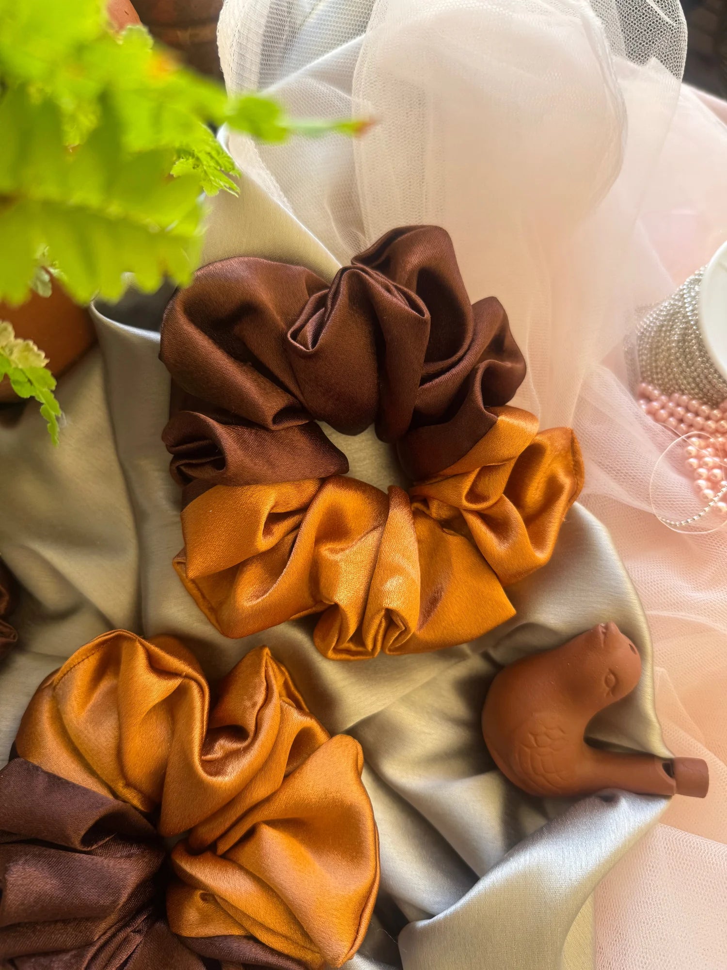 Terracotta Flower satin scrunchie in earthy gold and rich brown, handmade hair accessory by Bows and Bags India, displayed