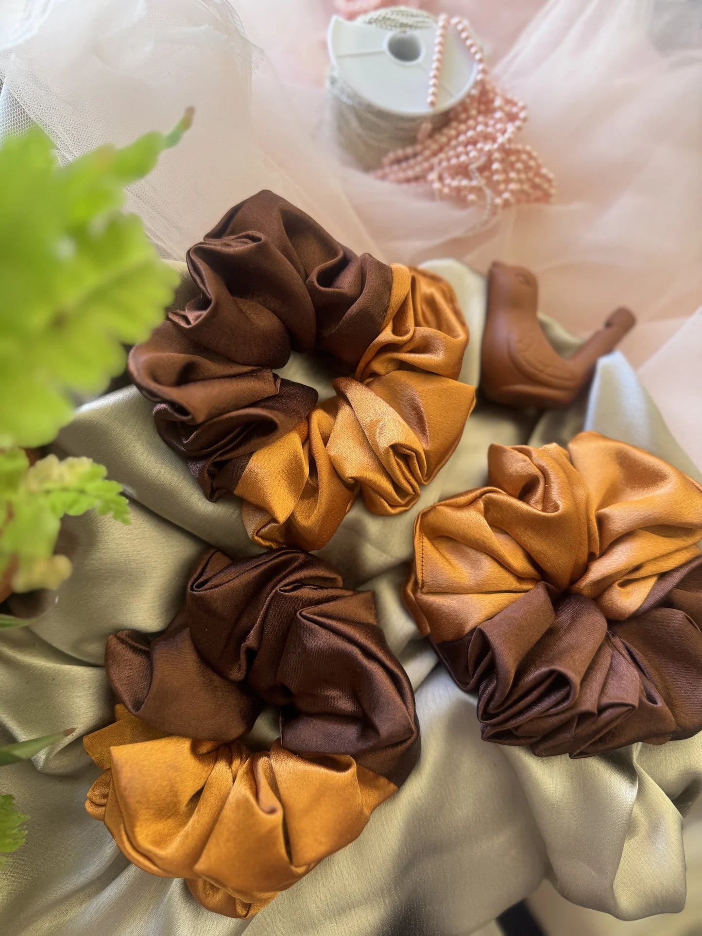 Flatlay of earthy satin scrunchies in terracotta and brown tones by Bows and Bags India handmade hair accessories collection