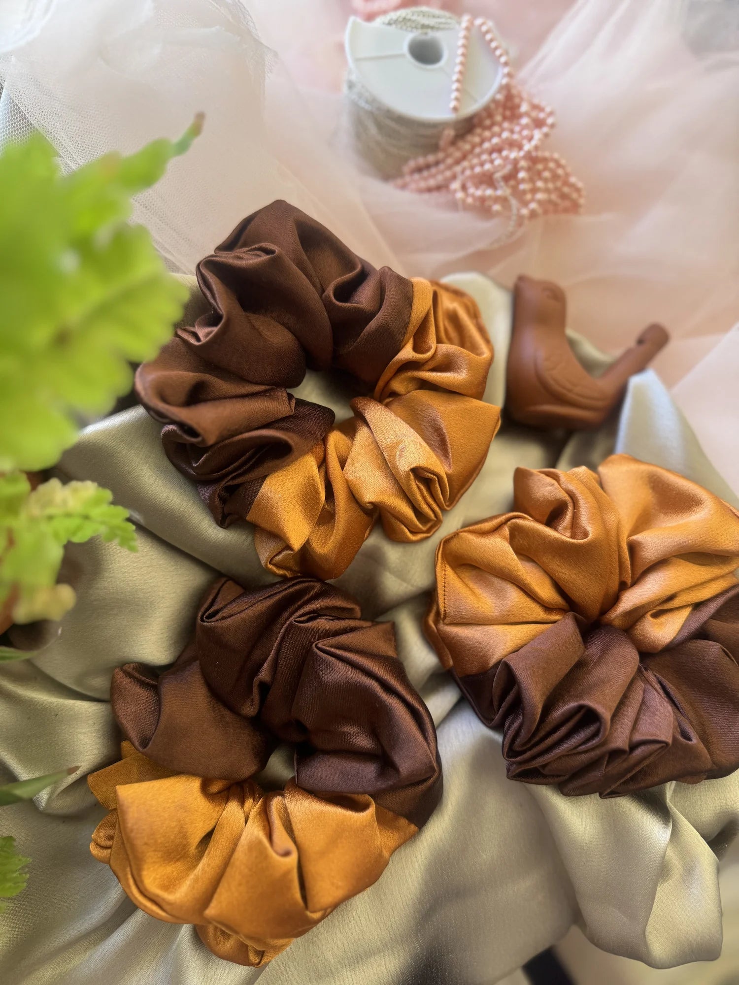 Flatlay of earthy satin scrunchies in terracotta and brown tones by Bows and Bags India handmade hair accessories collection